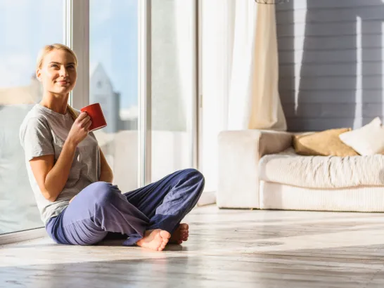 Eine glückliche Frau genießt eine Tasse Kaffee am Morgen.