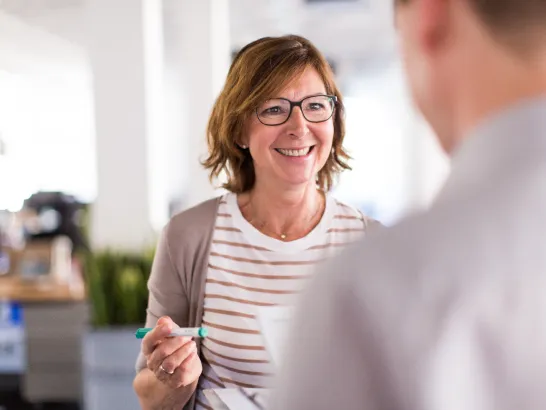 Eine Mitarbeiterin im Gespräch mit einem Kunden.