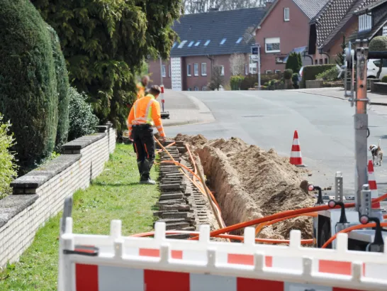 Netzausbau, auf der Baustelle werden Kabel in einen Schacht verlegt