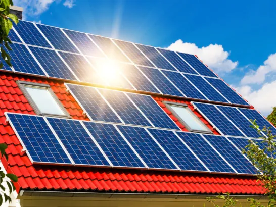 Ein Dach mit Solarmodulen, auf die die Sonne scheint.