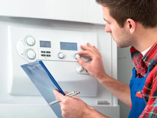 Ein Mitarbeiter wartet eine Heizungsanlage.