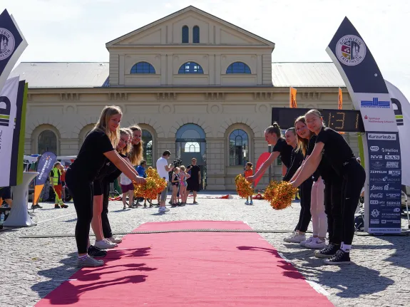 Ziel der Triathlonstrecke gesäumt mit Cheerleadern und Schweriner Marstall im Hintergrund.