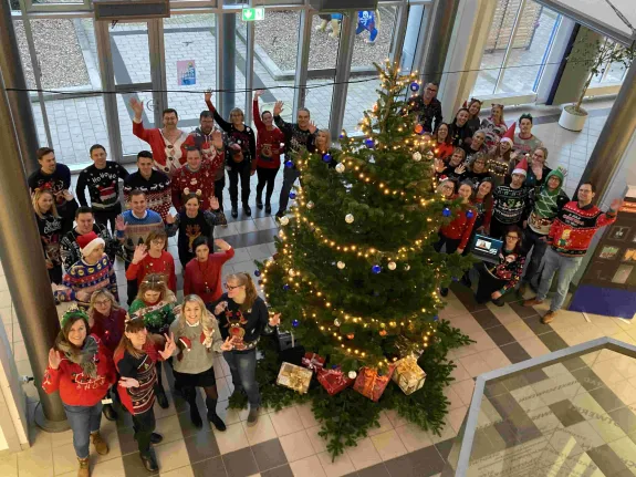 Mitarbeitende der der Stadtwerke im Foyer mit Weihnachtspullovern