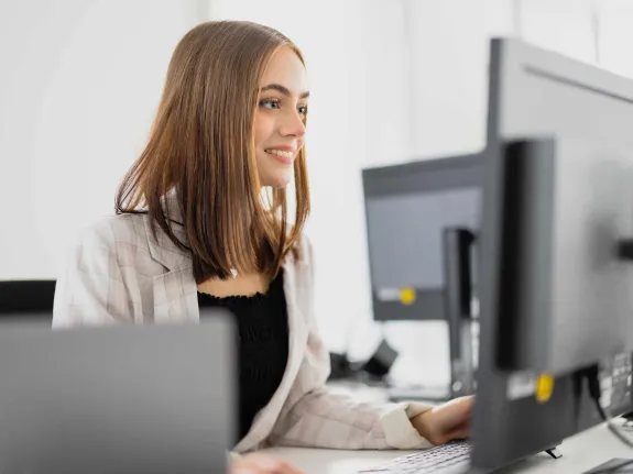 Junge Frau arbeitet am PC.