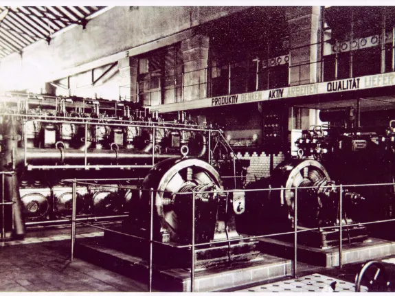 Schwarz-Weiß-Foto aus den 1950er Jahren eines Dieselmotors zur Stromerzeugung in der Maschinenhalle des E-Werk.
