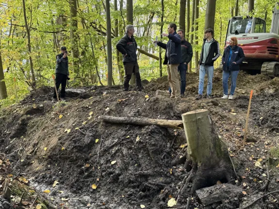 Personengruppe, die sich mitten im Moor im Gespräch befindet.