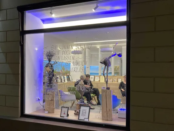Besucher sitzen im Stadtwerke-Kundencenter und unterhalten sich.