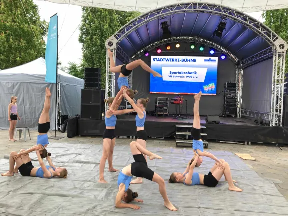 Acht Mädchen tanzen und turnen vor der Stadtwerke-Bühne.