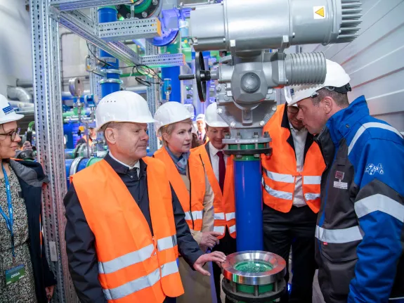 Bundeskanzler Scholz besichtigt gemeinsam mit Mitarbeitenden ein Geothermieheizwerk.
