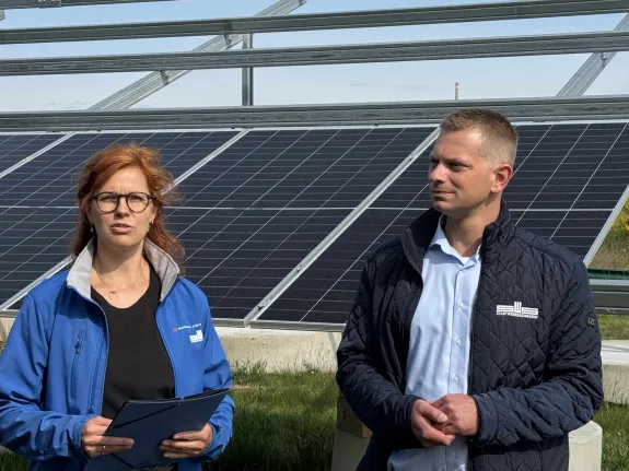 Eine Mitarbeiterin und ein Mitarbeiter der Stadtwerke Schwerin stehen vor einem PV-Modul.