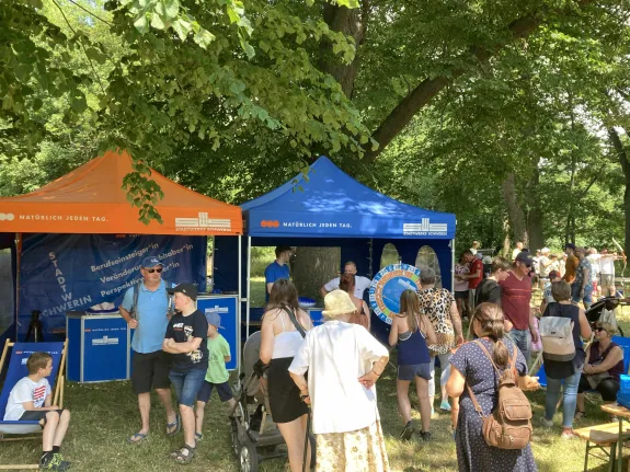Besuchergruppe steht vor Pavillons von den Stadtwerken.