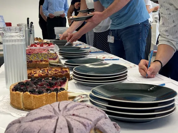 Nahaufnahme Selbstbedienung am Kuchenbuffet mit Ausfüllen von beiliegen Bewertungszetteln. 