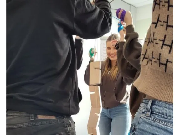 Junge Menschen bauen einen Turm aus Holzklötzen