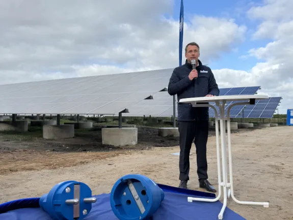 Stadtwerke Geschäftsführer Hanno Nispel hält eine Rede vor PV-Modulen
