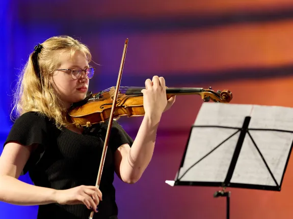 Junge Musikerin mit Violine und Notenständer