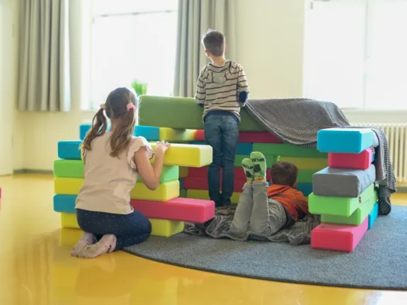 Eine Kindergruppe spielt mit Schaumstoffwürfeln