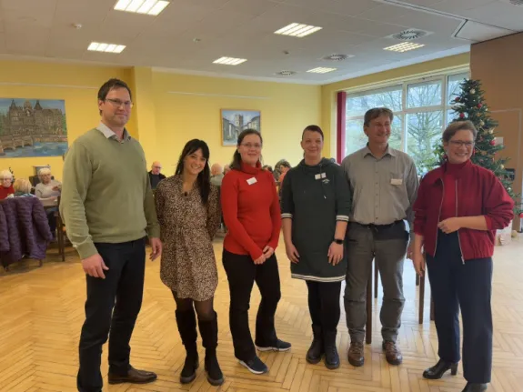 Eine Gruppe Menschen übergibt Spenden im Wärmeort