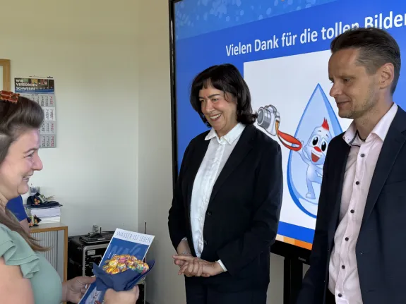 Die Geschäftsführung der WAG überreicht eine Urkunde an eine Preisträgerin