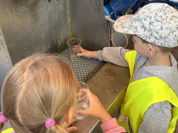 Zwei Kinder probieren Rohwasser