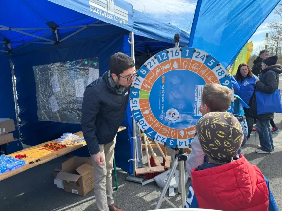 Ein Auszubildender der Stadtwerke Schwerin betreut Kinder am Glücksrad.