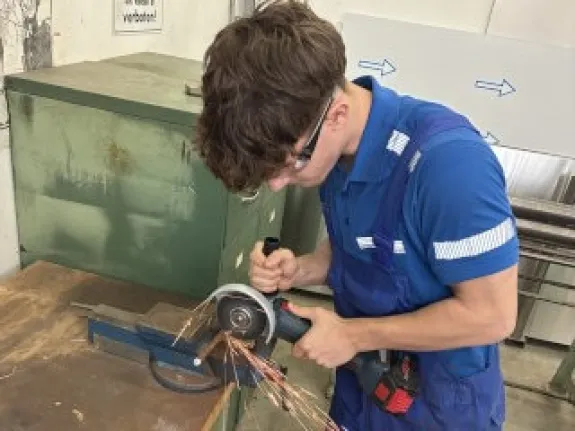 Ein junger Auszubildender arbeitet an einer Maschine