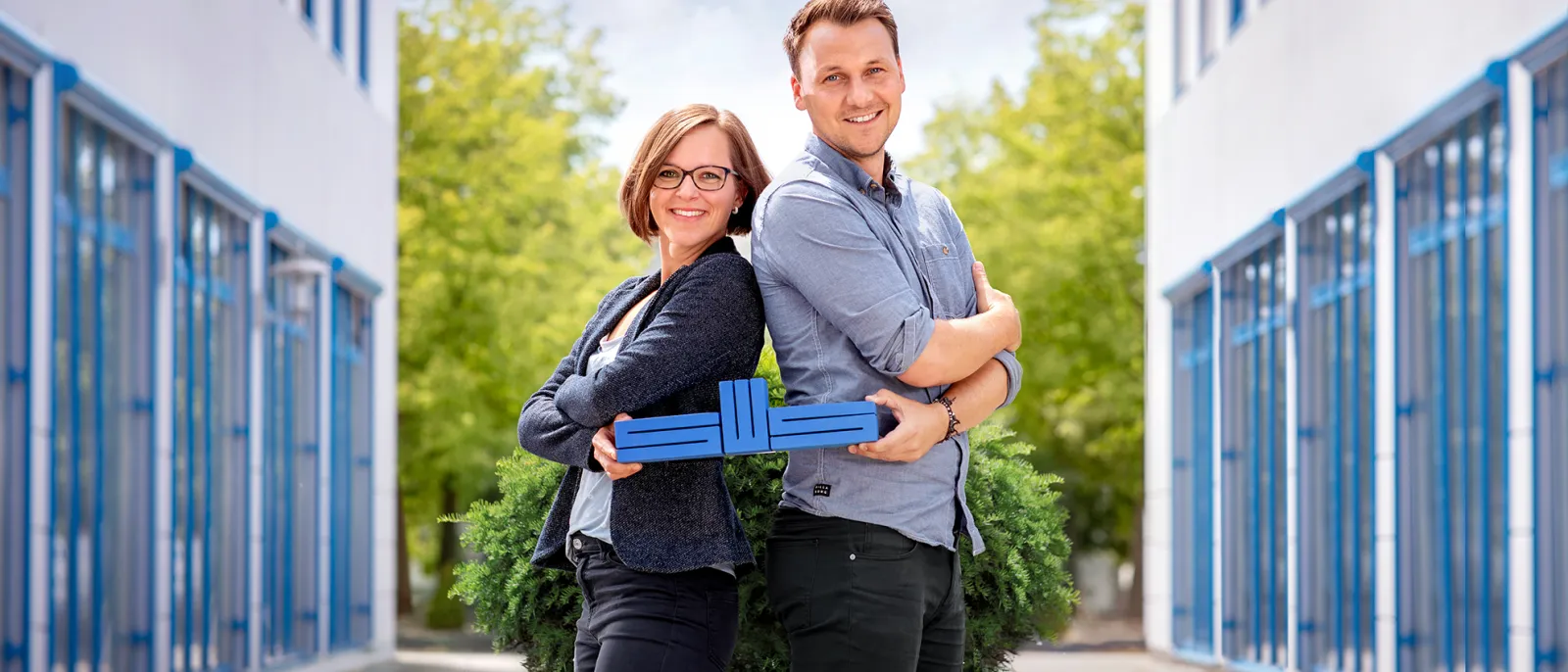 Mitarbeiter der Stadtwerke Schwerin halten das blaue SWS-Logo in den Händen.