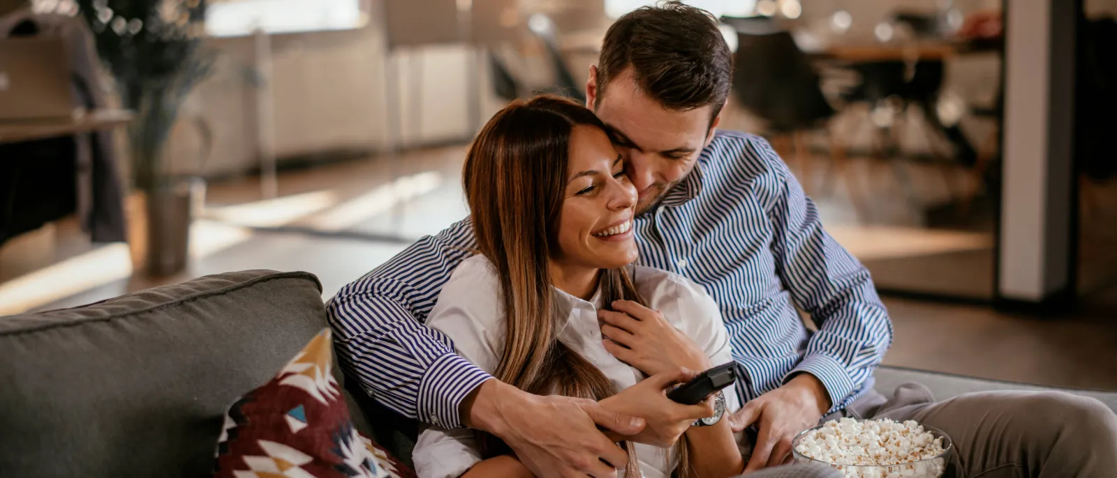 Ein Paar sitzt zu Hause vor dem Fernseher.