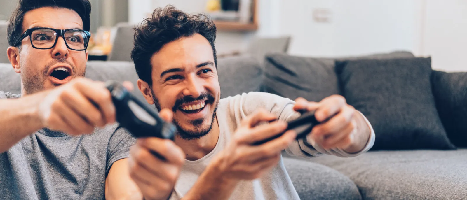 Zwei Männer haben Spaß beim Spielen mit der Spielekonsole.