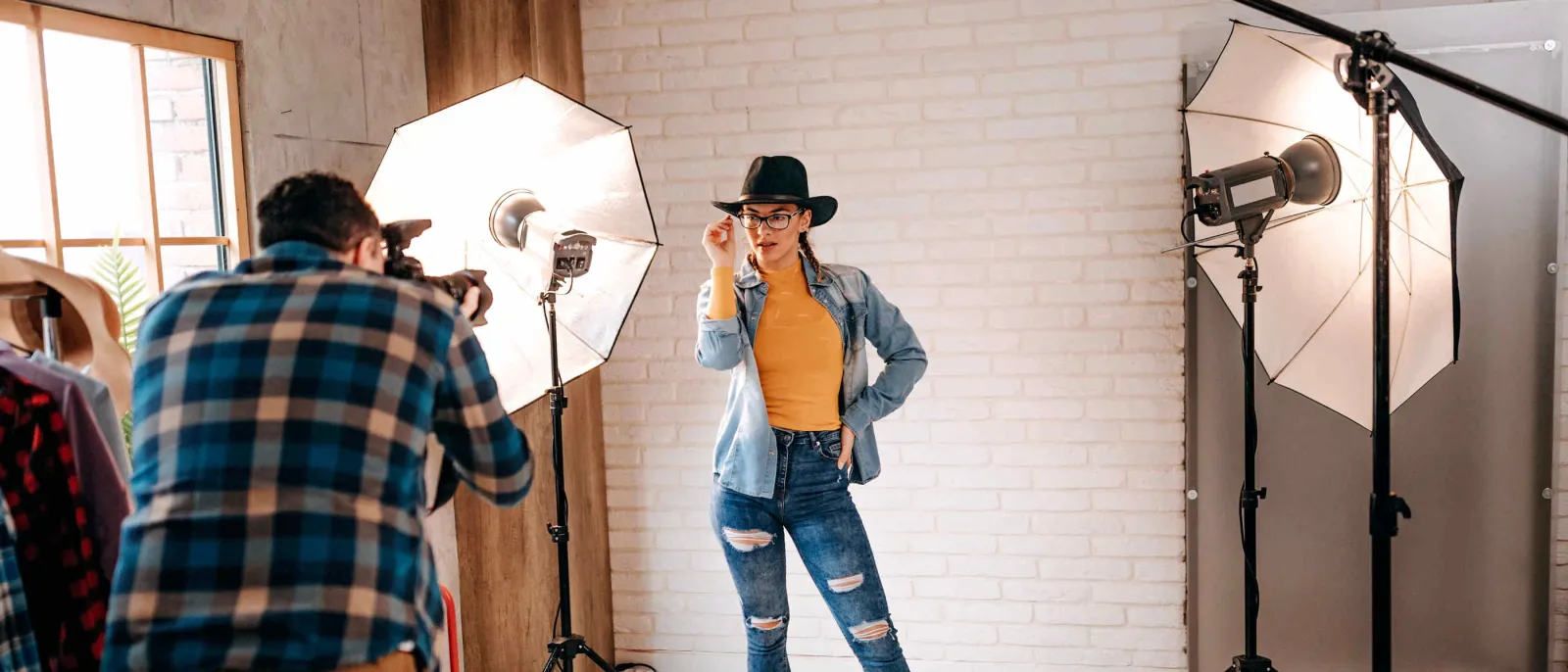 Ein Model wird beleuchtet und posiert vor einem Fotografen.