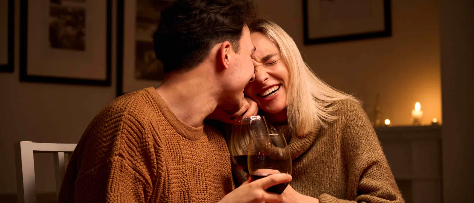 Ein Pärchen trinkt zuhause ein Glas Wein.