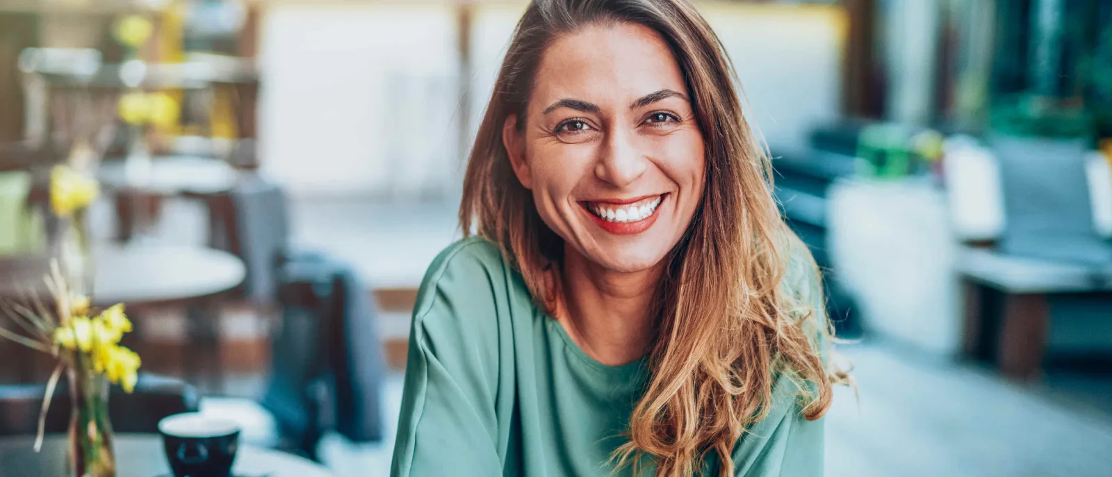 Eine glückliche Frau lächelt in die Kamera.