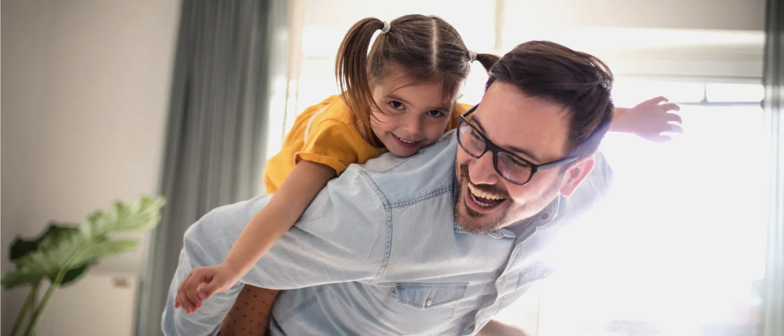 Vater und Tochter haben zuhause Spaß und spielen miteinander.