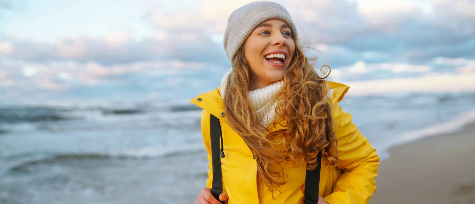 Eine Frau wandert am norddeutschen Strand.