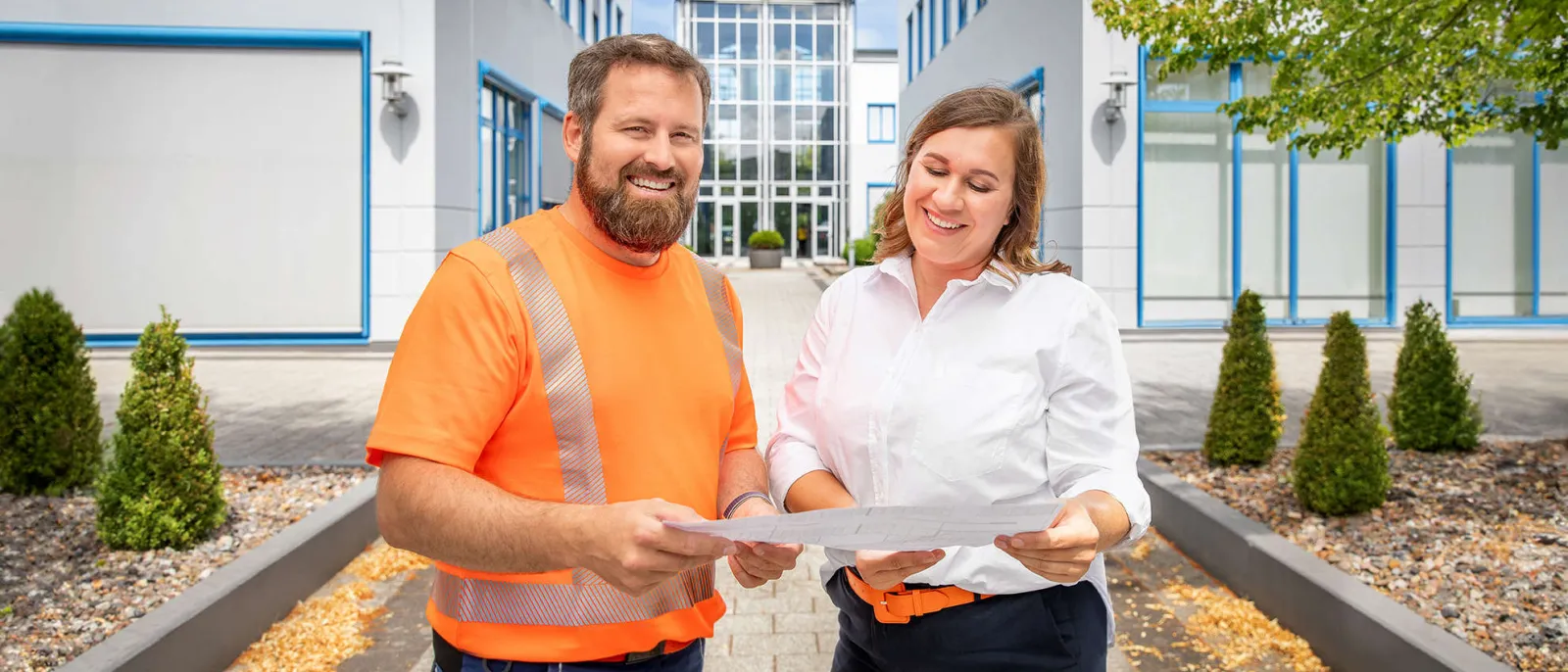 Eine Mitarbeiterin und ein Mitarbeiter der SWS unterhalten sich im Innenhof der SWS-Gebäude.