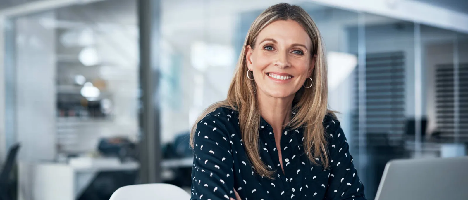 Eine Mitarbeiterin sitzt vor einem Laptop.