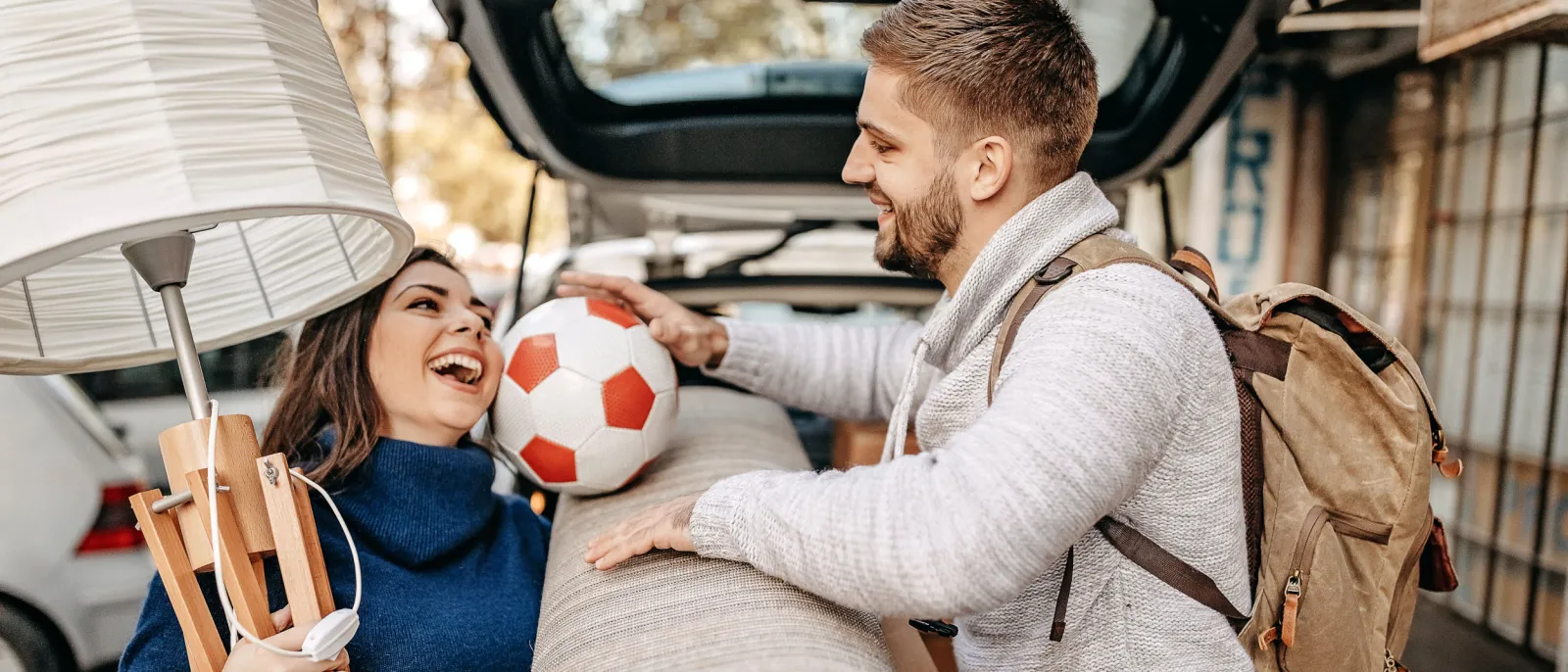 Eine Frau und ein Mann beladen ein Auto, um umzuziehen.
