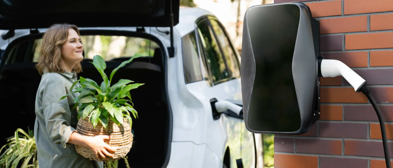 Eine Frau lädt ihr E-Auto an einer Wallbox.