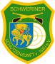 grünes Wappen, oben gekreuzte Gewehre, links der goldene Wappenritter von Schwerin, rechts dahinter einer Zielscheibe