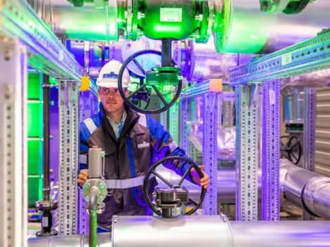 Stadtwerkemitarbeiter im Wärmepumpenraum einer Geothermie-Anlage.