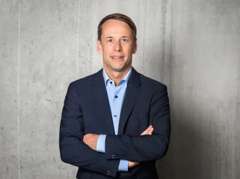 SWS Geschäftsführer Hanno Nispel vor einer grauen Mauer