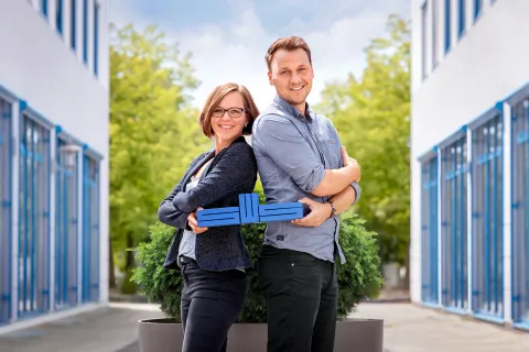 Mitarbeiter der Stadtwerke Schwerin halten das blaue SWS-Logo in den Händen.
