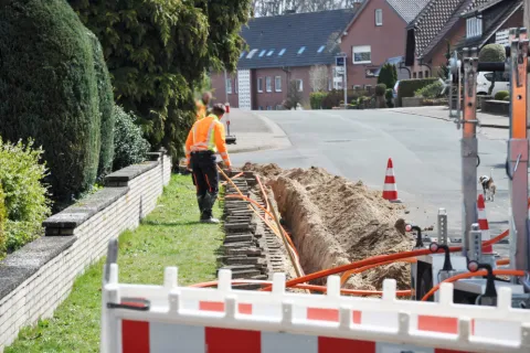 Netzausbau, auf der Baustelle werden Kabel in einen Schacht verlegt