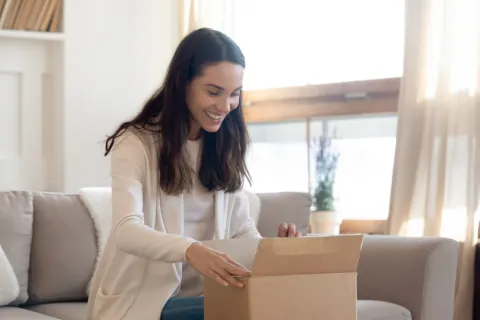 Eine Frau packt ein Paket aus.
