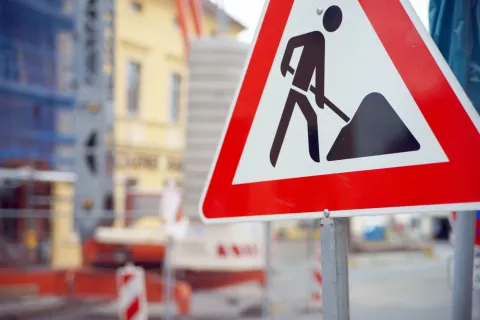 Ein Baustellenschild vor einer Baustelle in der Stadt.