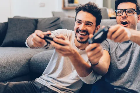 Zwei junge Menge spielen Videospiel und haben viel Spaß