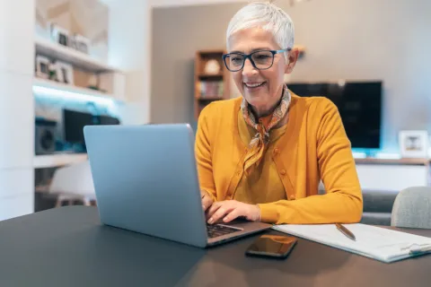 Frau sitzt vor ihrem Laptop