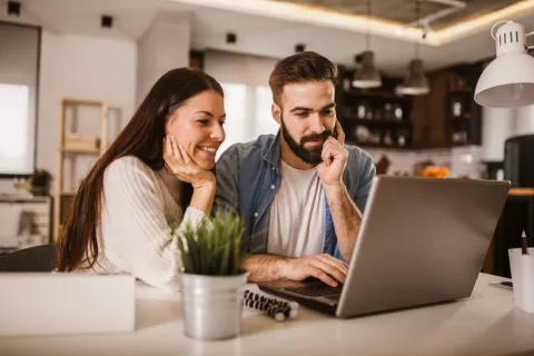 Glückliches Paar schaut zusammen auf ein Notebook
