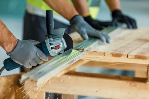 Bauarbeiter schneiden mit der Flex Trockenbauständer