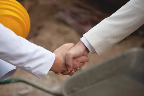 Zwei Menschen geben sich die Hand