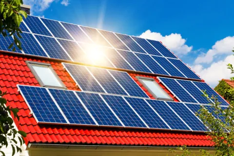 Ein Dach mit Solarmodulen, auf die die Sonne scheint.